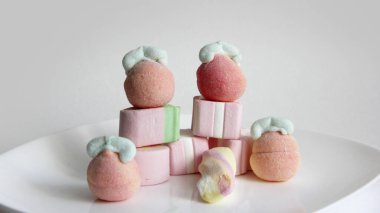 Beyaz arka planda cam bir vazoda şekerleme. Vazodaki farklı şekillerde şekerlemeler. Şekerler.