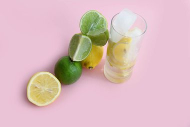 Limonlu, limonlu ve naneli kokteyl. Limonlu, limonlu ve naneli. Pembe arka planda limon ve limon dilimleri ve dilimde limon.