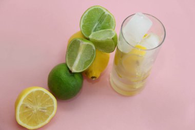 Limonlu, limonlu ve naneli kokteyl. Limonlu, limonlu ve naneli. Pembe arka planda limon ve limon dilimleri ve dilimde limon.