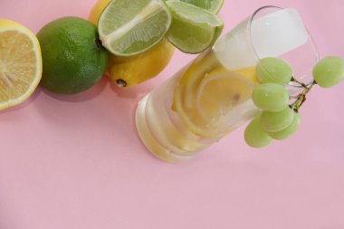 Limonlu, limonlu ve naneli kokteyl. Limonlu, limonlu ve naneli. Pembe arka planda limon ve limon dilimleri ve dilimde limon.