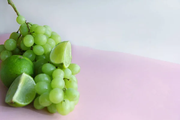 Ein Bund Grüner Trauben Und Limetten Limettenscheiben Nahaufnahme Vor Hellem — Stockfoto