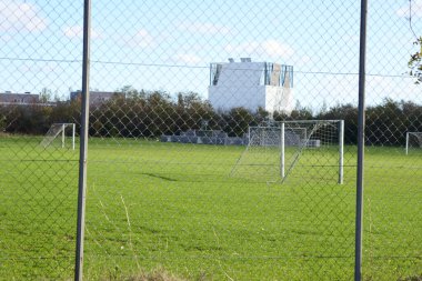 Güneşli bir günde boş ve büyük bir yeşil futbol sahası