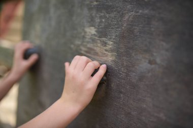 Oyun parkında duvara tırmanan bir kız.