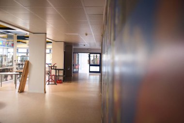 Duvarında renkli resimler olan boş bir okul koridoru.