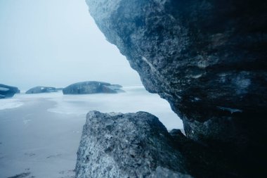 Büyük kaya ve kaya sisli ve sisli okyanus suyunda