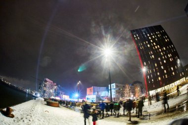 Karlı bir gecede sokakta yürüyen bir kalabalık