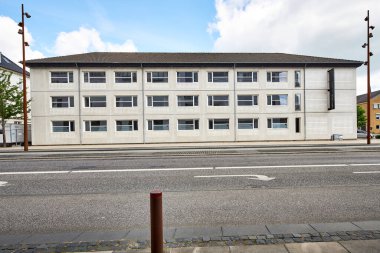 Yolun kenarındaki modern beyaz beton bina.