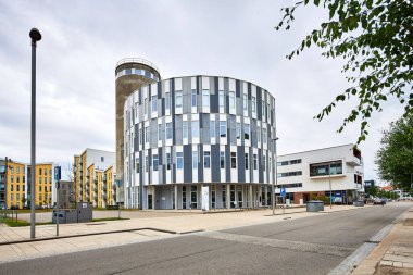 Pencereleri olan yuvarlak, modern bir bina.