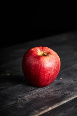 Tahta bir masada taze kırmızı elma.