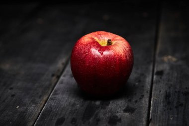 Tahta bir masada taze kırmızı elma.