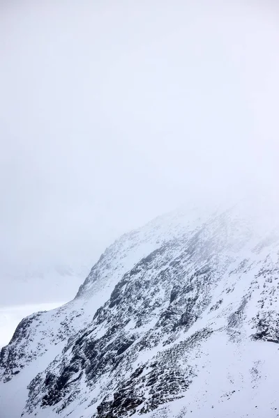 Tepesinde kar olan harika dağ manzarası. 