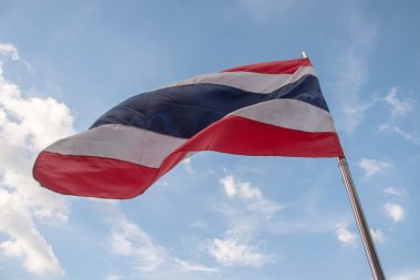 Mavi gökyüzü arka plan ile Tayland bayrağı sallayarak