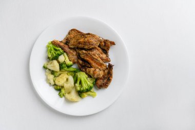 Izgara brokoli, karnabahar ve beyaz tabakta tavuk göğsü.