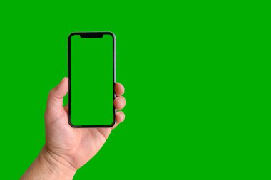 Yeşil arka planda yeşil ekranlı cep telefonu tutan adam, yakın plan. Metin için boşluk