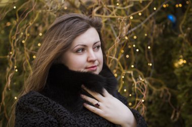 Işıklar arka plan üzerinde sıcak tutan bir kürkünüz kadında