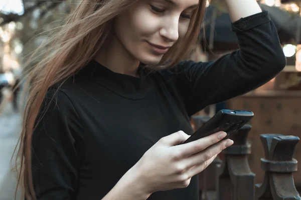 Счастливая женщина печатает смс на смартфоне — стоковое фото