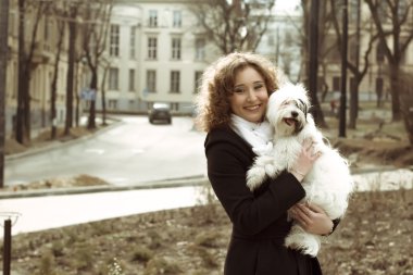 Gülümseyen kadın ile köpek sokakta oynarken