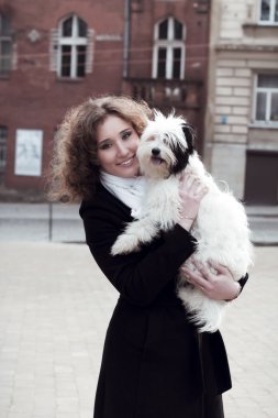 Şehirdeki köpek oynamaktan mutlu sarışın kadın