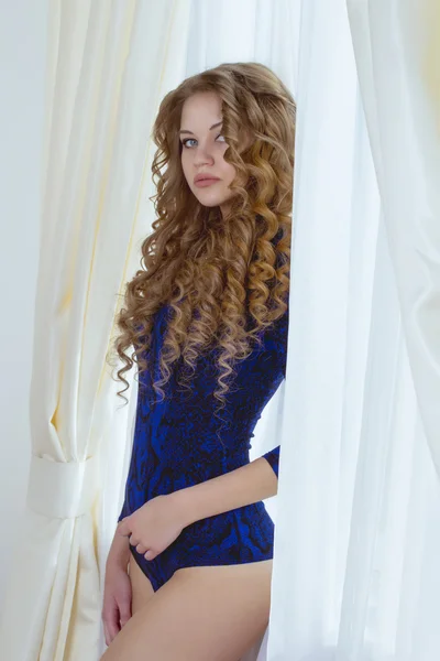 Bella donna con lunghi capelli biondi alla finestra — Foto Stock