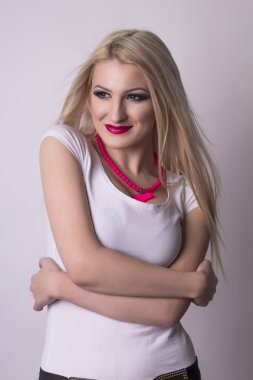 Gri bir arka plan üzerinde sevimli gülümseyen kadın