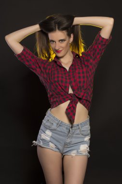 Kot şort ve ekose gömlek gülümseyen esmer kadın