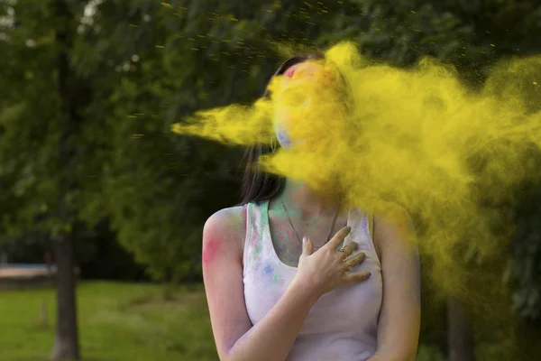 Woman with paint holi blowing into her face — Stock Photo, Image