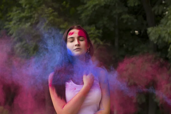 Τρυφερή γυναίκα με χρώμα σε σκόνη που εκρήγνυται γύρω της — Φωτογραφία Αρχείου