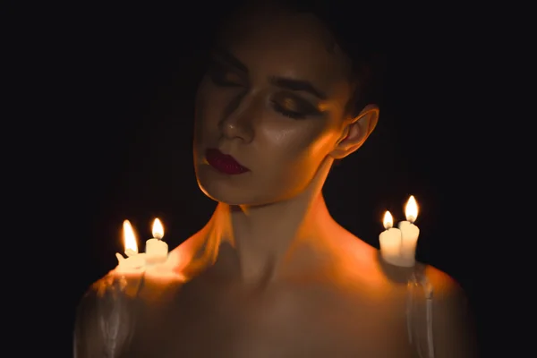 Mulher atraente com velas nos ombros — Fotografia de Stock