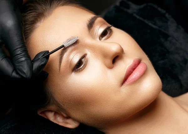 化妆品师在粉末永久处理之前用刷子梳理眉毛 一张漂亮脸蛋模特的合影 — 图库照片