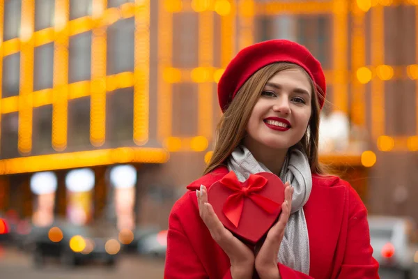 Merry Młoda Kobieta Nosi Czerwony Beret Płaszcz Trzymając Pudełko Kształcie — Zdjęcie stockowe