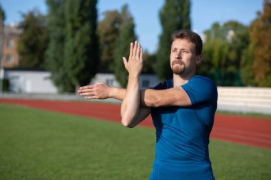 Yakışıklı sakallı adam stadyumdaki antrenmandan önce ısınıyor. Metin için boşluk