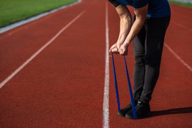 Genç jimnastikçi dışarıda lastikle spor yapıyor. Stadyumda. Metin için boşluk