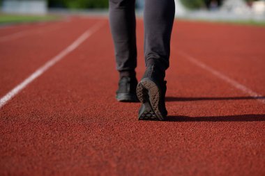 Atletik genç adam kırmızı koşu pistinde koşuyor. Metin için boşluk