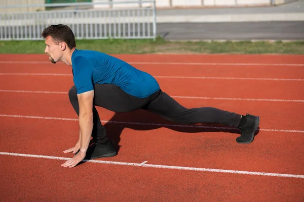 Musculoso Joven Haciendo Estiramiento Durante Entrenamiento Una Pista Atletismo — Foto de Stock