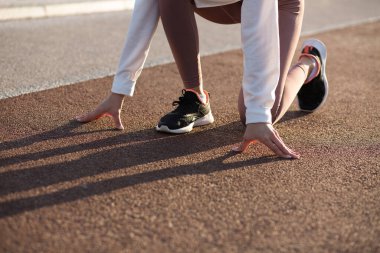 Başlangıç pozisyonunda koşan koşucu bir kadının yakın çekimi başlamaya hazır. Metin için boşluk