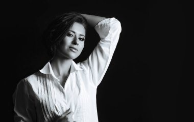 Stüdyoda erkek gömleği giymiş kıvırcık saçlı güzel bir genç kadın. Boş boşluk