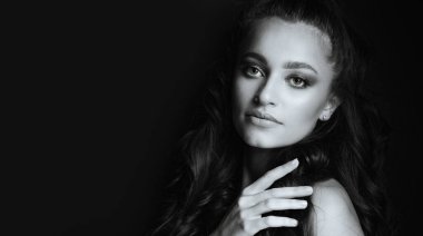 Gölgelerde poz veren görkemli, uzun saçlı genç bir kadının yakın plan portresi. Metin için boşluk