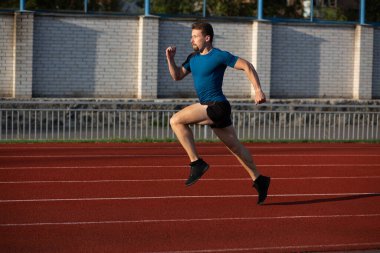 Stadyumda koşan sağlıklı genç bir adam. Metin için boşluk