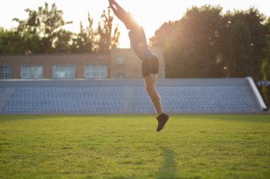 Eğitimi sırasında çimlere atlayan aktif bir sporcu. Boş boşluk
