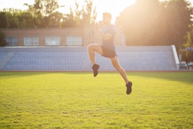 Akşamki antrenman sırasında stadyuma atlayan aktif bir sporcu. Metin için boşluk