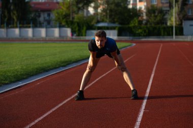Spor giyimli sakallı adam stadyumda koşmaya hazır. Metin için boşluk