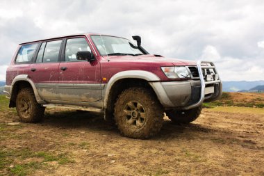 Yazın toprak kırsal yolda off-road aracı. Araba yağmurdan sonra çamur ve çamurla kaplı.