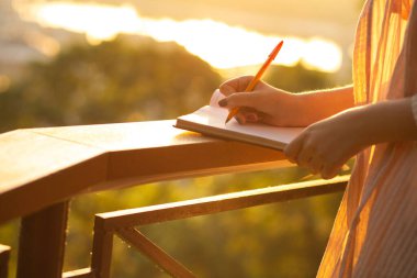 Sabahları dışarıda planlamacı gibi yazan sıradan giyinmiş bir kadının yakın plan fotoğrafı. Metin için boşluk