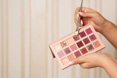 Profesyonel makyaj sanatçısı fırçalı pembe gözlük paletini kullanıyor. Metin için boşluk