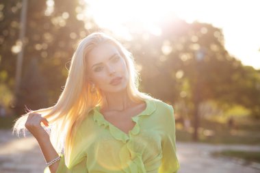 Gün batımında yürüyen uzun saçlı zarif bir kadının yakın plan sokak portresi. Tex için boşluk