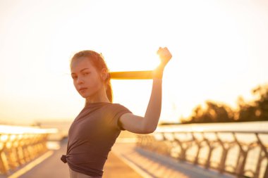 Sportif kızıl saçlı kadın sabahları lastik bantla egzersiz yapıyor. Tex için boşluk