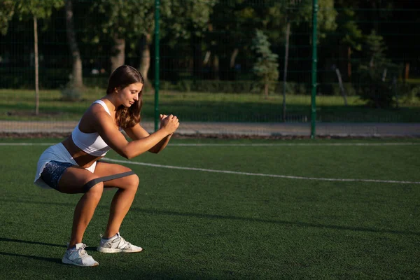 Muskulös Passform Kvinna Gör Knäböj Med Gym Tuggummi Fotbollsplanen Tomrum — Stockfoto