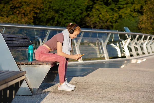 Red Haired Fitness Woman Listening Music Using Her Smartphone Workout — Stock Photo, Image