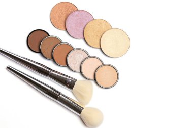 Beyaz arka planda fırçaları olan farklı tonlarda toz fosforları ve bronzlaştırıcılar. Moda makyaj konsepti. Metin için boşluk