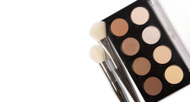 Beyaz arkaplandaki fırçalarla yüz kaplaması için basılı fosforlu kalemler ve bronzlaştırıcıların kozmetik paleti. Metin için boşluk